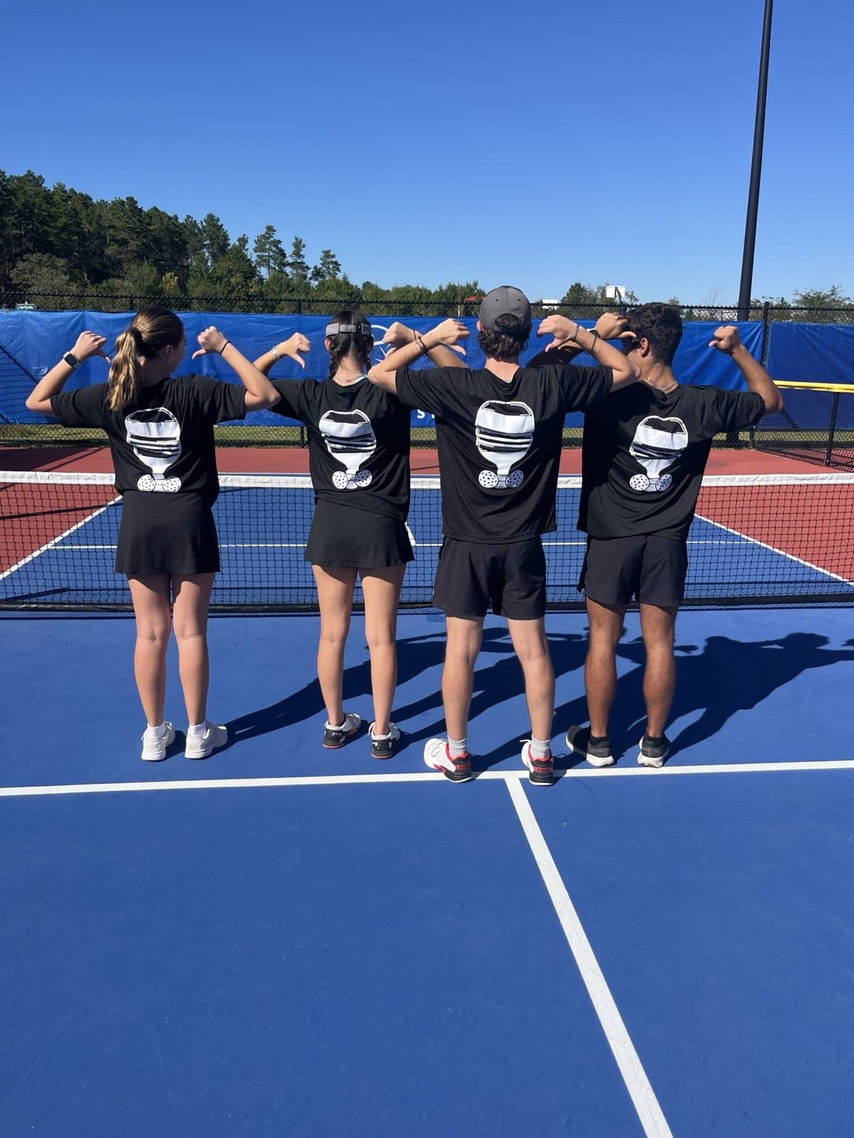 The crew pointing at the Nasty Pickle logo on their shirts